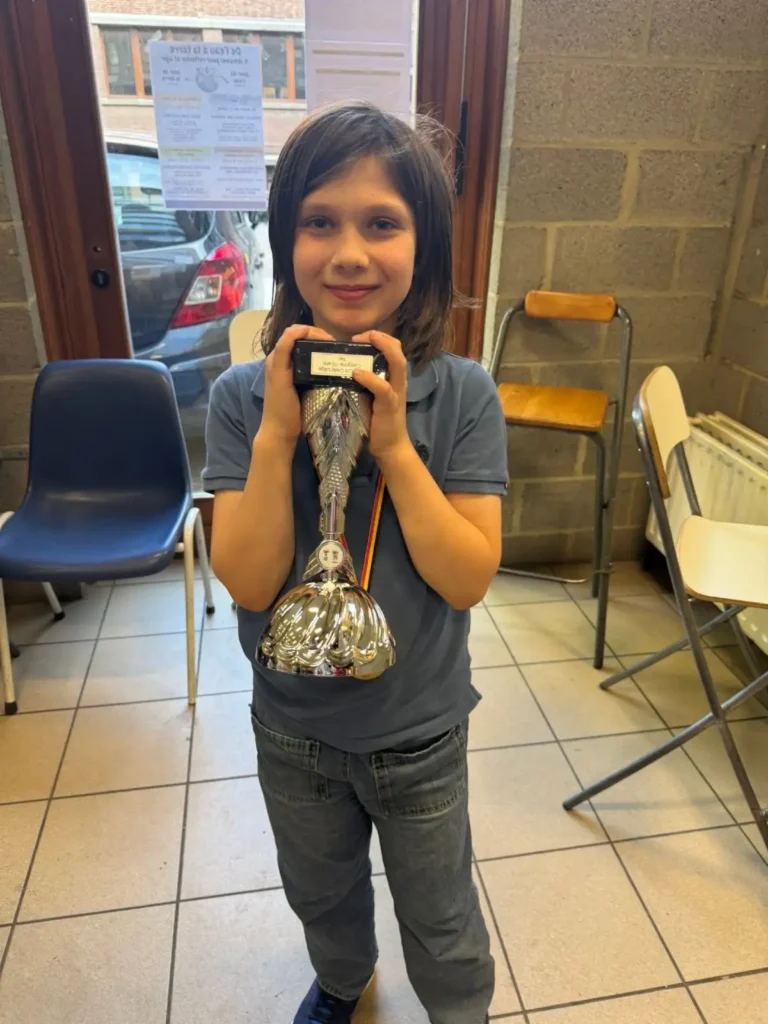 Miro holding his first-place trophy after winning the Belgian National Youth Chess Championship.